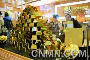 參展的金行在現(xiàn)場(chǎng)展臺(tái)用金磚壘出小“金字塔”，吸引了眾多投資者的目光。
